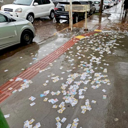 Chuva 'cola' santinhos no chão em frente a escola eleitoral no Coophavila II