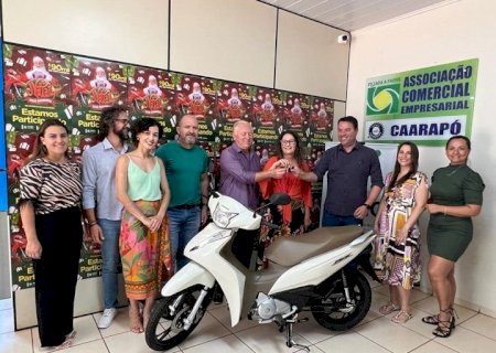 Autoridades fazem entrega da moto zero km da promoção de Natal da ACEC para a ganhadora de Caarapó